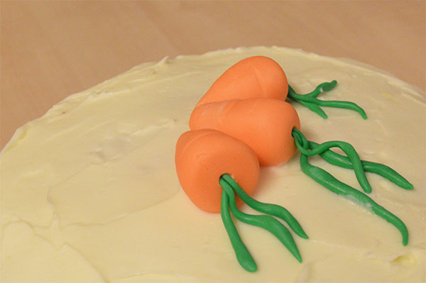 Decorating a carrot cake with cream cheese frosting